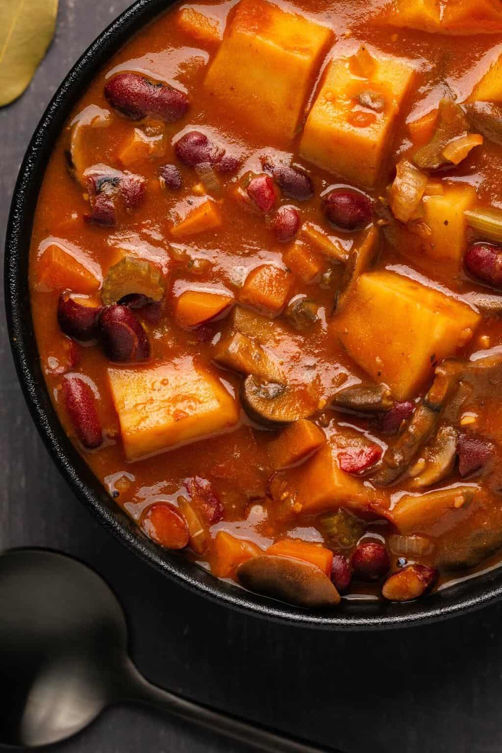 Vegan stew in a black bowl. 