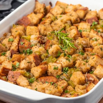 Vegan stuffing with fresh rosemary in a white dish.