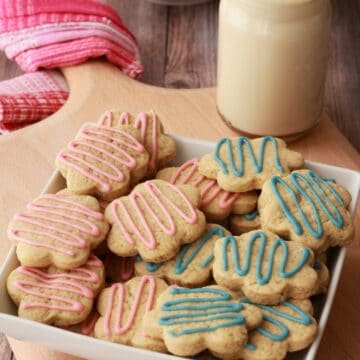 Vegan sugar cookies stacked up in a white bowl.