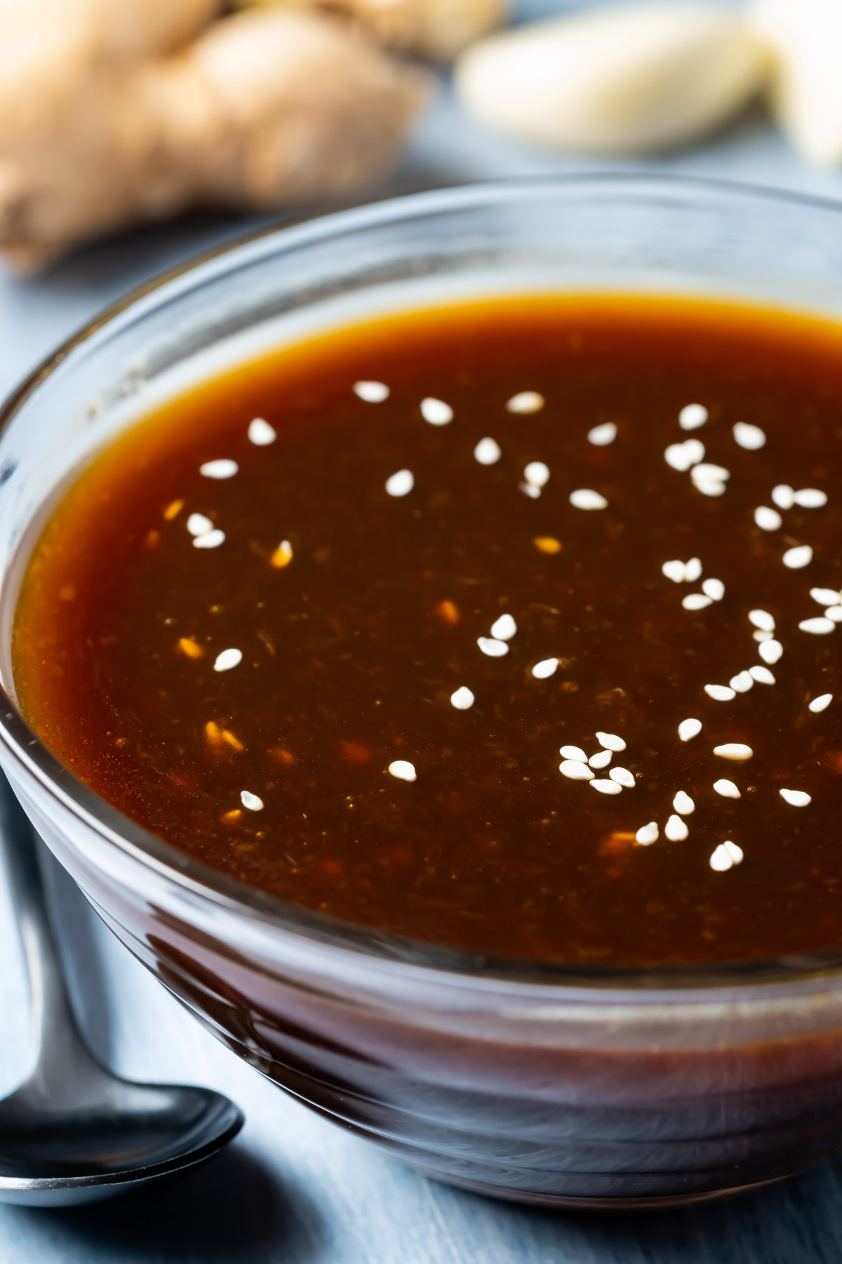 Vegan teriyaki sauce topped with sesame seeds in a glass dish.