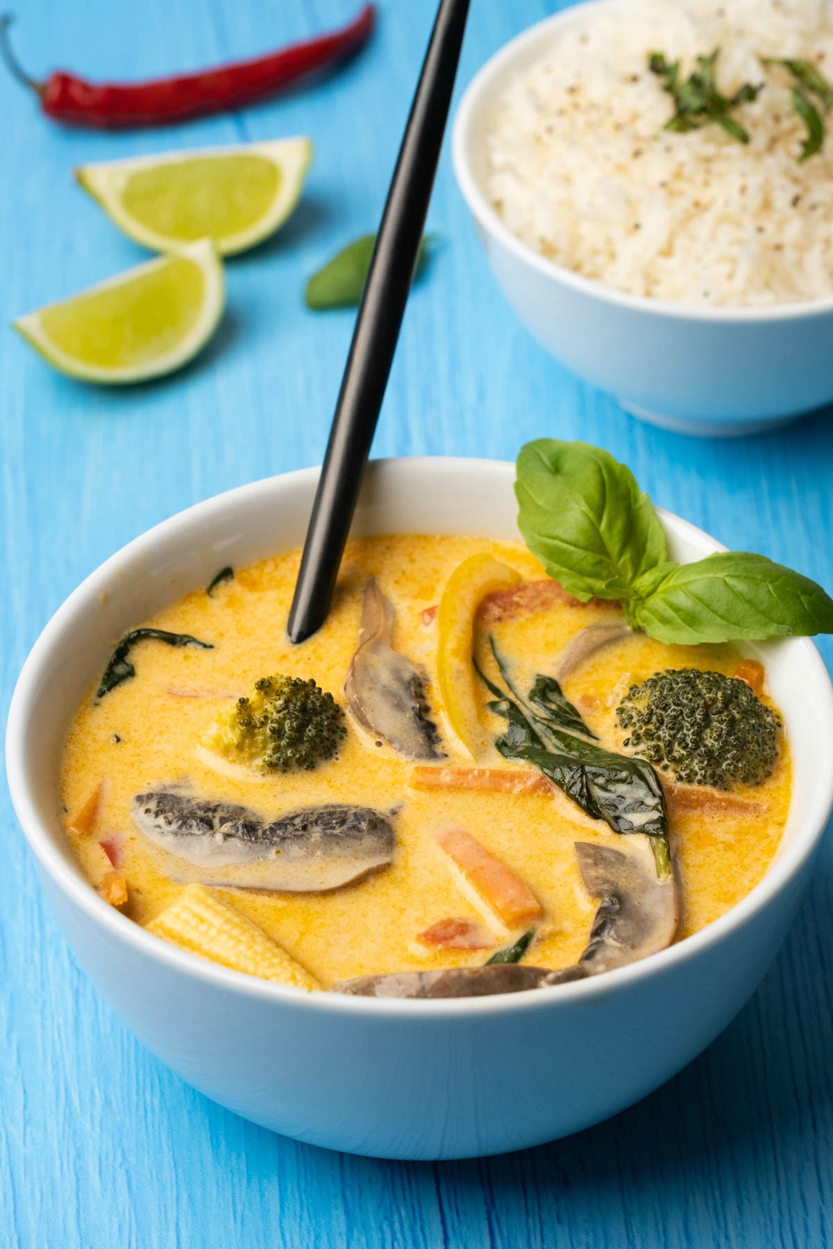 Vegan Thai red curry in a white bowl with a spoon. 