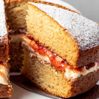 Victoria sponge cake on a white cake stand.